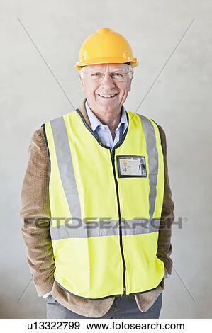 Stock Photo - Smiling businessman wearing hard hat. Fotosearch