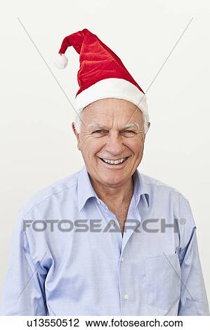 Smiling businessman wearing Santa hat View Large Photo Image Stock Image - Smiling businessman wearing Santa hat. Fotosearch