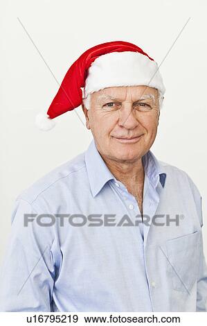 Stock Photo - Smiling businessman wearing Santa hat. Fotosearch