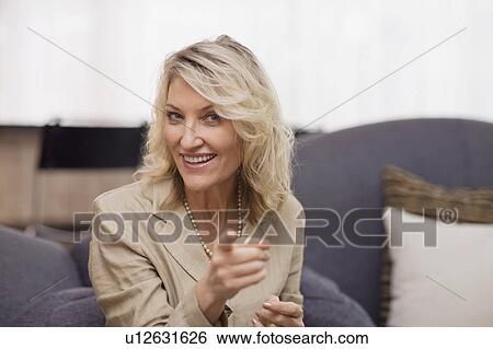 Stock Photograph - Smiling businesswoman talking on couch. Fotosearch