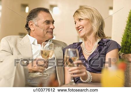 Smiling couple having wine together View Large Photo Image Stock Image - Smiling couple having wine together. Fotosearch