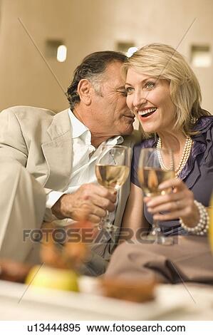 Stock Photography - Smiling couple having wine together. Fotosearch