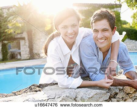 Smiling couple hugging by pool View Large Photo Image Stock Photograph - Smiling couple hugging by pool. Fotosearch