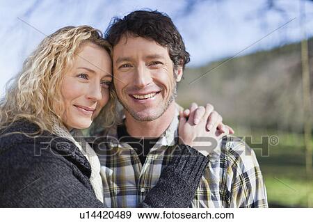 Smiling couple hugging outdoors View Large Photo Image Stock Photo - Smiling couple hugging outdoors. Fotosearch