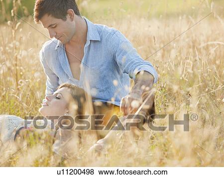 Smiling couple relaxing in wheatfield View Large Photo Image Stock Photo - Smiling couple relaxing in wheatfield. Fotosearch