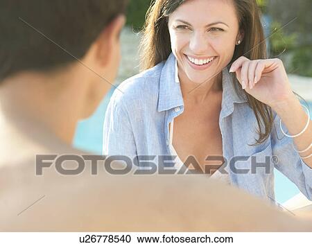 Stock Image - Smiling couple talking outdoors. Fotosearch