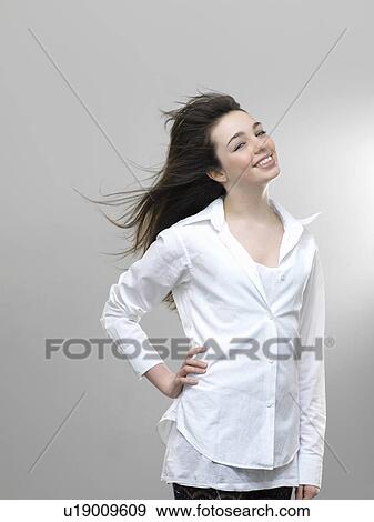 Stock Photo - Smiling girl’s hair blowing in wind. Fotosearch
