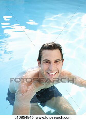 Stock Photography - Smiling man swimming in pool. Fotosearch