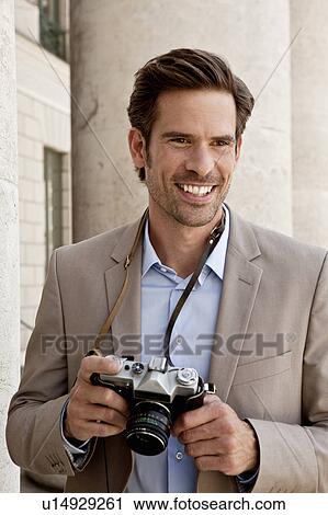 Smiling man wearing camera View Large Photo Image Stock Image - Smiling man wearing camera. Fotosearch