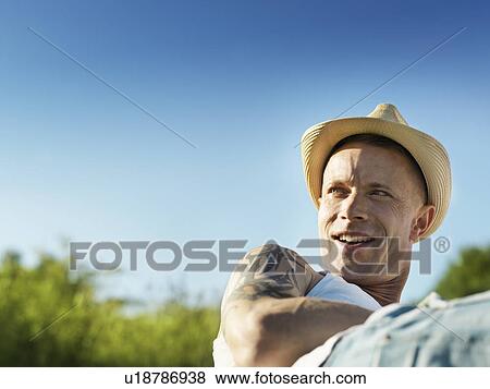 Smiling man wearing sunhat outdoors View Large Photo Image Stock Photo - Smiling man wearing sunhat outdoors. Fotosearch