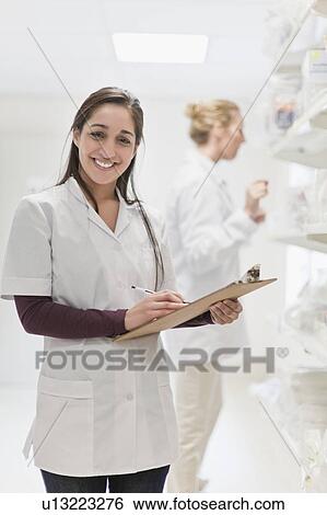 Smiling nurse holding clipboard View Large Photo Image Stock Photograph - Smiling nurse holding clipboard. Fotosearch