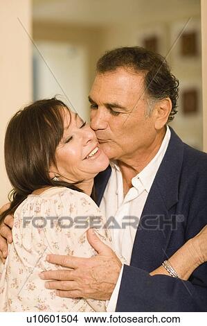 Picture - Smiling older couple kissing. Fotosearch
