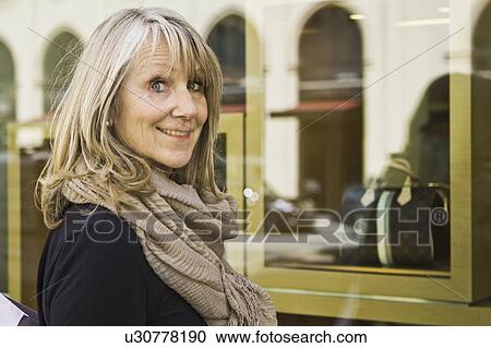 Smiling older woman window shopping View Large Photo Image Stock Image - Smiling older woman window shopping. Fotosearch