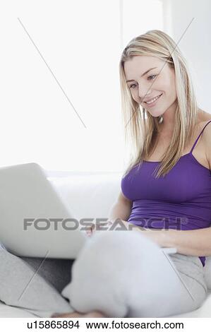 Picture - Smiling teenage girl using laptop. Fotosearch