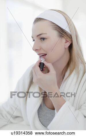 Stock Photo - Smiling woman applying makeup. Fotosearch