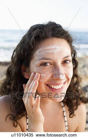 Smiling woman applying sunscreen to face View Large Photo Image Stock Photography - Smiling woman applying sunscreen to face. Fotosearch