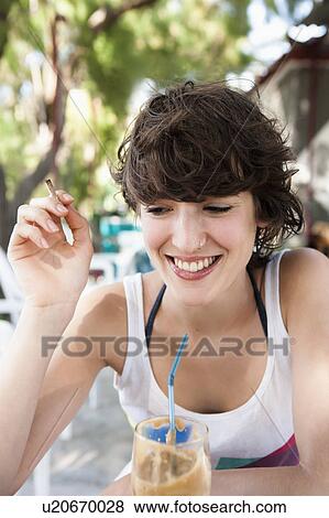 Smiling woman drinking through straw View Large Photo Image Stock Photo - Smiling woman drinking through straw. Fotosearch
