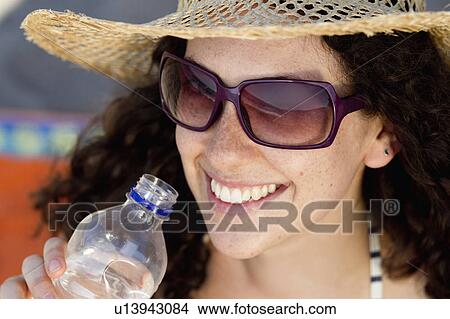 Smiling woman drinking water View Large Photo Image Picture - Smiling woman drinking water. Fotosearch