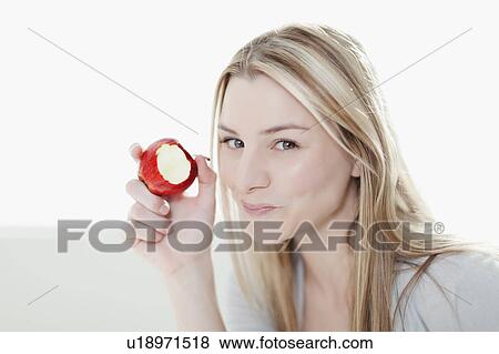 Stock Photo - Smiling woman eating apple. Fotosearch