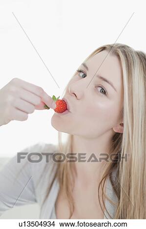 Smiling woman eating strawberry View Large Photo Image Picture - Smiling woman eating strawberry. Fotosearch