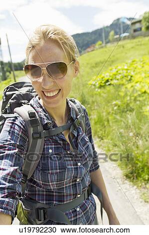 Stock Image - Smiling woman hiking with backpack. Fotosearch