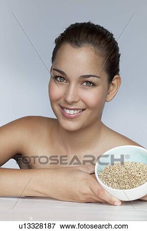 Stock Photo - Smiling woman holding bowl of grains. Fotosearch
