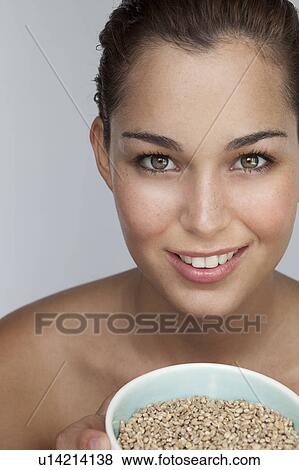 Smiling woman holding bowl of grains View Large Photo Image Stock Photo - Smiling woman holding bowl of grains. Fotosearch