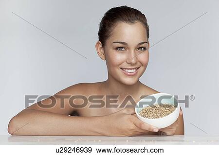 Smiling woman holding bowl of grains View Large Photo Image Stock Photo - Smiling woman holding bowl of grains. Fotosearch