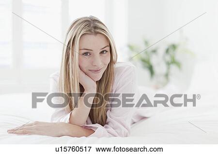 Smiling woman laying on bed View Large Photo Image Stock Photo - Smiling woman laying on bed. Fotosearch
