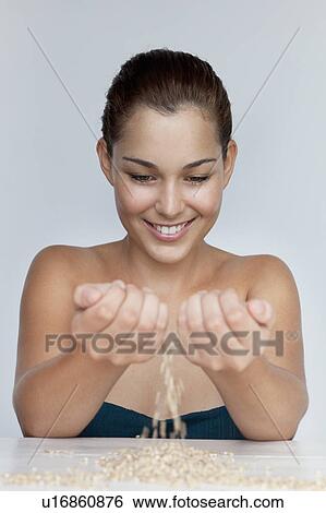 Smiling woman playing with grains View Large Photo Image Stock Photograph - Smiling woman playing with grains. Fotosearch