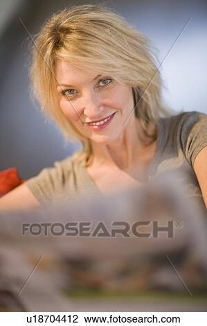 Smiling woman reading newspaper View Large Photo Image Stock Image - Smiling woman reading newspaper. Fotosearch