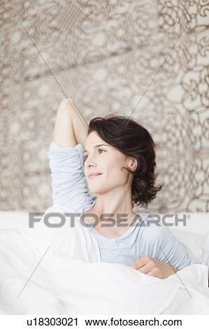 Smiling woman sitting up in bed View Large Photo Image Stock Image - Smiling woman sitting up in bed. Fotosearch