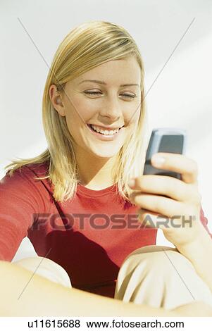 Stock Photo - Smiling woman using cell phone. Fotosearch