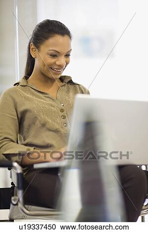 Smiling woman using laptop View Large Photo Image Stock Image - Smiling woman using laptop. Fotosearch