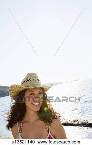 Smiling woman wearing sunhat on beach View Large Photo Image Stock Image - Smiling woman wearing sunhat on beach. Fotosearch