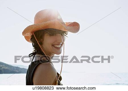 Smiling woman wearing sunhat on beach View Large Photo Image Stock Image - Smiling woman wearing sunhat on beach. Fotosearch