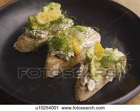 Stock Image - Smoked trout toasts with relish. Fotosearch