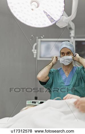 Stock Photo - Surgeon preparing in operating room. Fotosearch