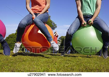 Stock Image - Teams racing on exercises balls. Fotosearch