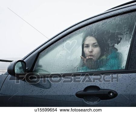 Teenage girl blowing kiss from car View Large Photo Image Picture - Teenage girl blowing kiss from car. Fotosearch
