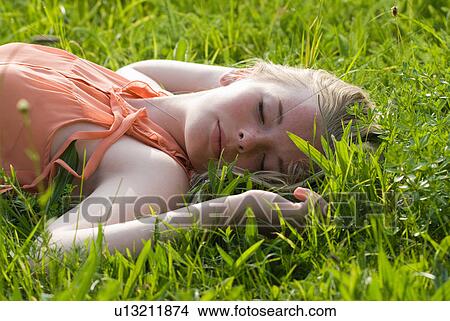 Teenage girl laying in tall grass View Large Photo Image Picture - Teenage girl laying in tall grass. Fotosearch