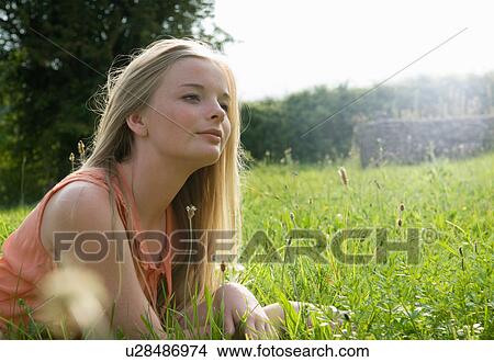 Teenage girl laying in tall grass View Large Photo Image Picture - Teenage girl laying in tall grass. Fotosearch