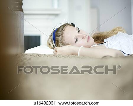 Stock Image - Teenage girl listening to headphones. Fotosearch