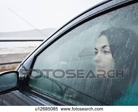 Teenage girl looking out wet car window View Large Photo Image Stock Photography - Teenage girl looking out wet car window. Fotosearch