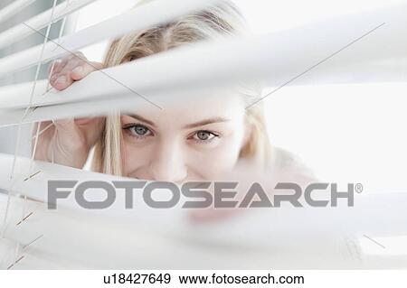 Teenage girl peering through blinds View Large Photo Image Stock Photo - Teenage girl peering through blinds. Fotosearch