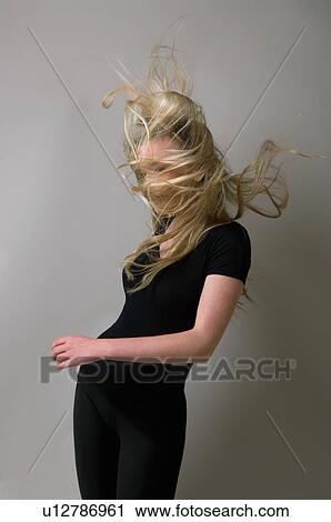 Stock Image - Teenage girl’s hair blowing in wind. Fotosearch