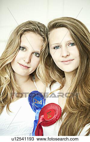 Stock Image - Teenage girls wearing prize ribbons. Fotosearch