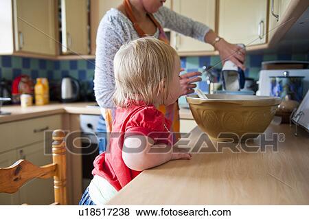 Stock Photo - Toddler girl baking with mother. Fotosearch