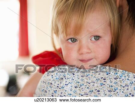 Toddler girl crying on mother’s shoulder View Large Photo Image Stock Image - Toddler girl crying on mother’s shoulder. Fotosearch
