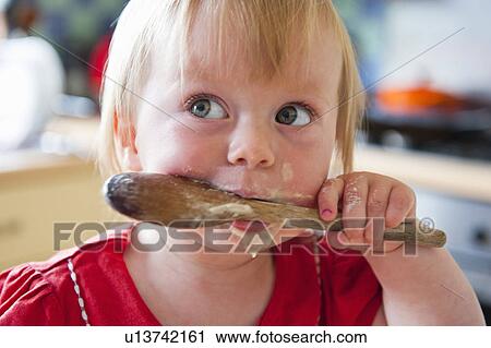Toddler girl licking wooden spoon View Large Photo Image Stock Image - Toddler girl licking wooden spoon. Fotosearch